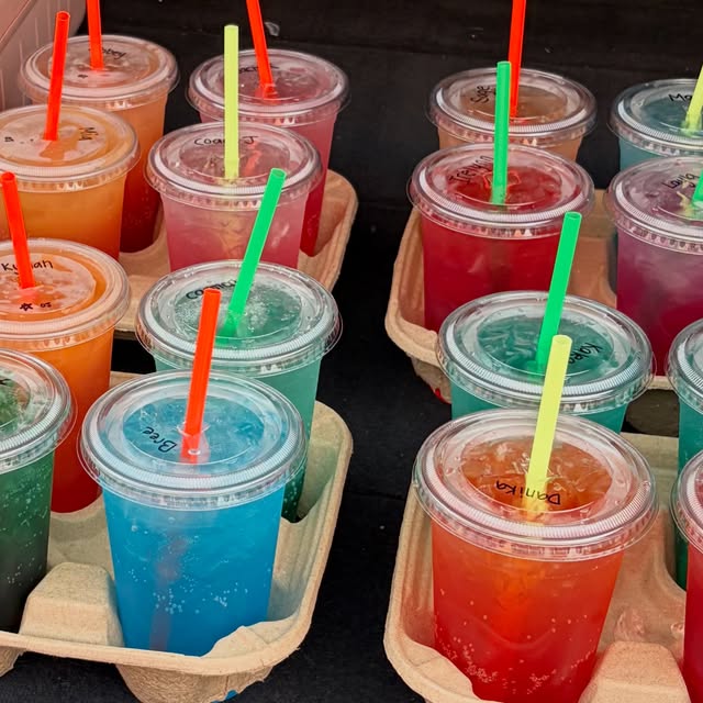 A tray full of colorful iced drinks
